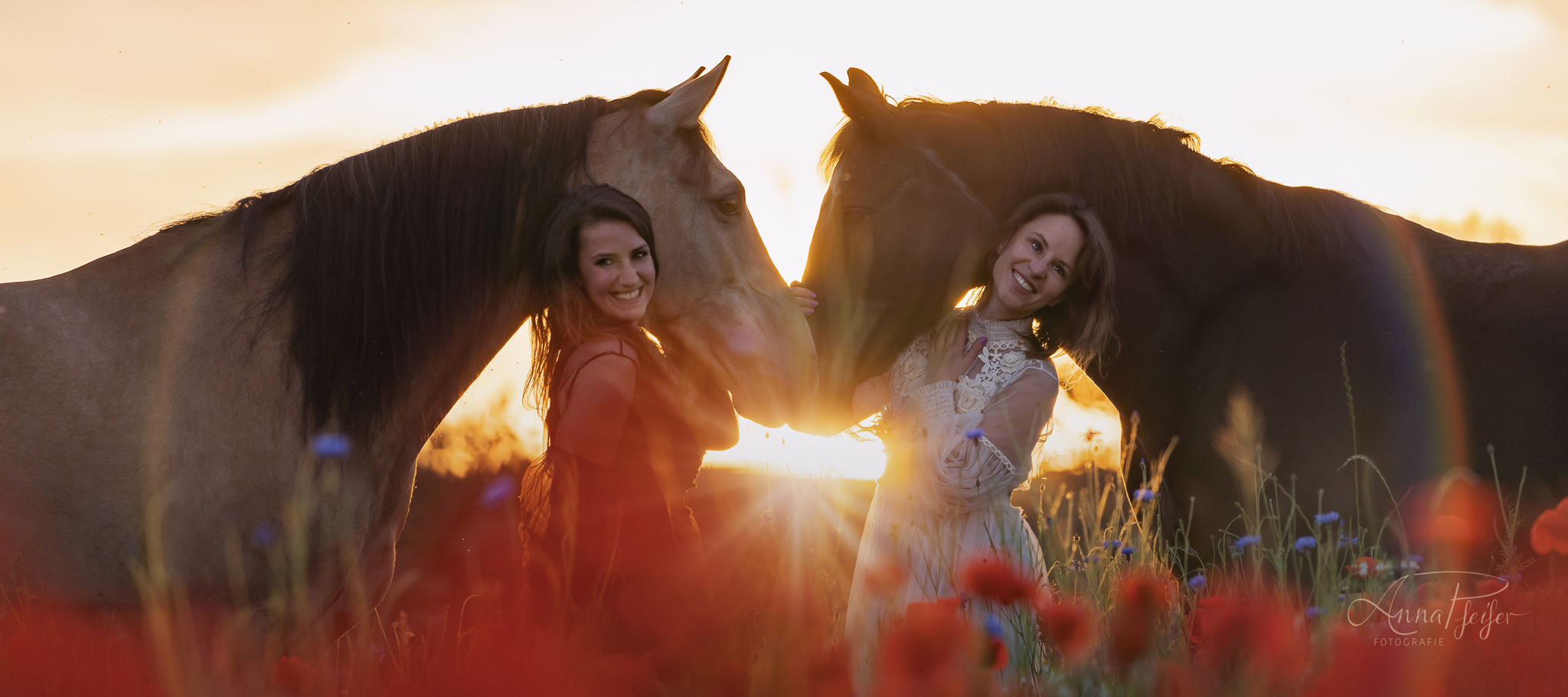 Zwei Mädchen mit Pferden im Sonnenuntergang